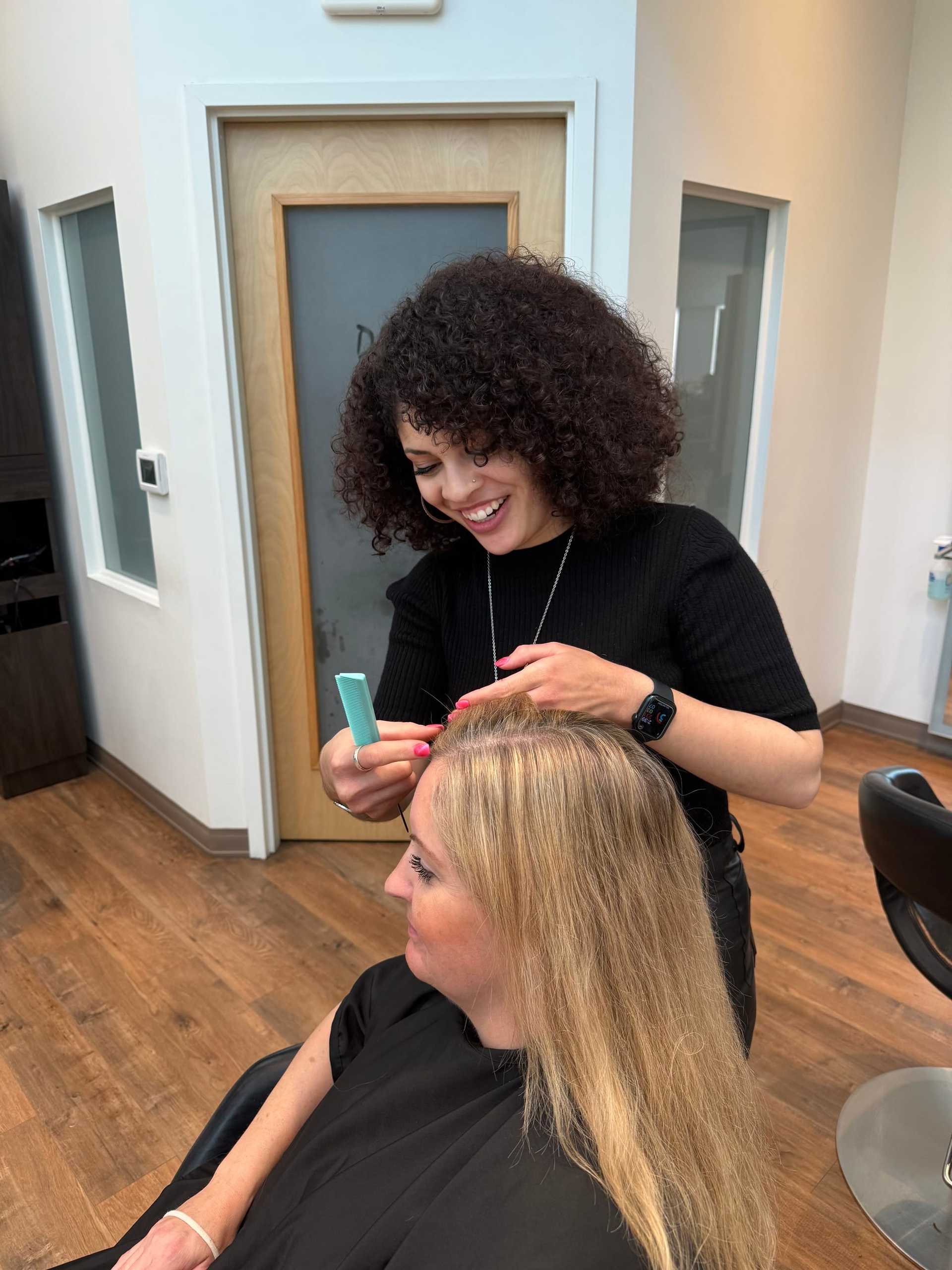Hairdresser styling client's hair in a salon.